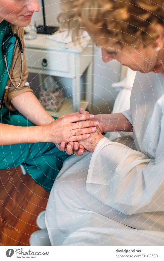 Ärztin hält Hand des Patienten Krankheit Medikament Arzt Krankenhaus sprechen Mensch Frau Erwachsene alt authentisch Freundlichkeit Vertrauen Mitgefühl