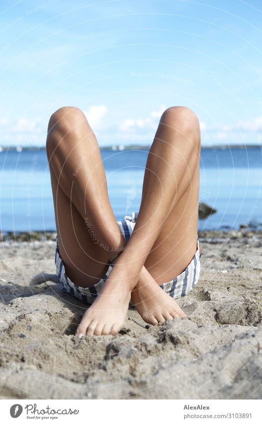 1500 | Junge Frau liegt mit gekreuzten Beinen am Strand Stil schön sportlich Fitness Wellness Sommer Sommerurlaub Sonnenbad Meer Jugendliche 18-30 Jahre