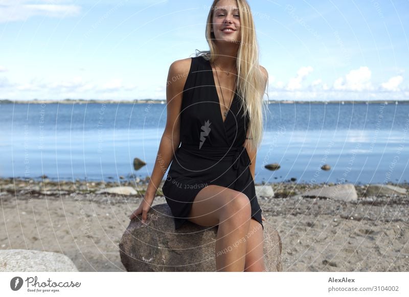 Lächelnde, junge Frau in schwarzem Kleid an der Ostsee Stil Freude schön Wohlgefühl Sommer Sommerurlaub Sonne Sonnenbad Strand Meer Junge Frau Jugendliche