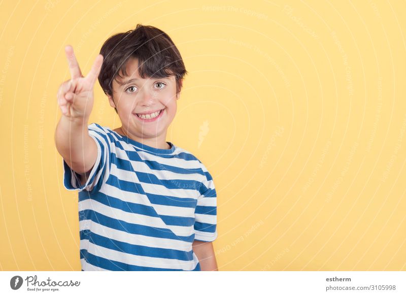 Kind lächelt und macht das Siegeszeichen. Nummer zwei. Freude Glück Erfolg Mensch maskulin Junge Kindheit Hand Finger 1 8-13 Jahre Ziffern & Zahlen Fitness