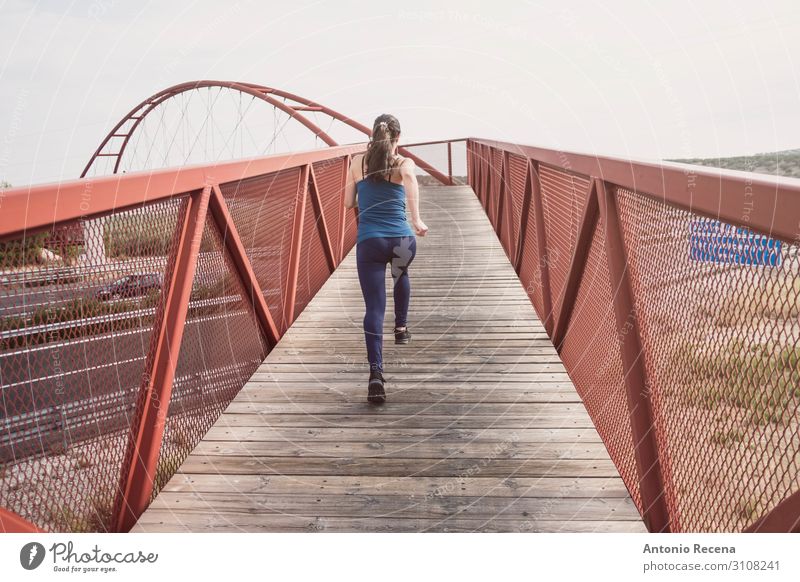 mittlere erwachsene Frau, die auf einer Brücke läuft. Lifestyle Sport Erwachsene Architektur Fußgänger Autobahn Einsamkeit rennen 30s mittlere erwachsene Person