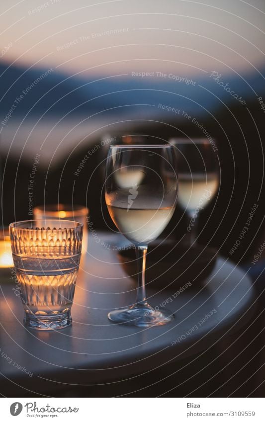 A table with two wine glasses outside in summer in a cosy evening atmosphere with candles Getränk Alkohol Wein Erholung Ferien & Urlaub & Reisen Weißwein Sommer