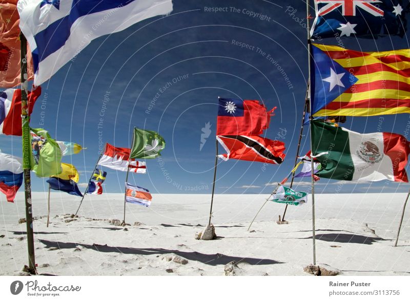 Verschiedene Flaggen wehen farbenfroh vor dem Hintergrund der Salar de Uyuni Salzwüste in Bolivien. Sand Wolkenloser Himmel Schönes Wetter Wind Wüste Südamerika