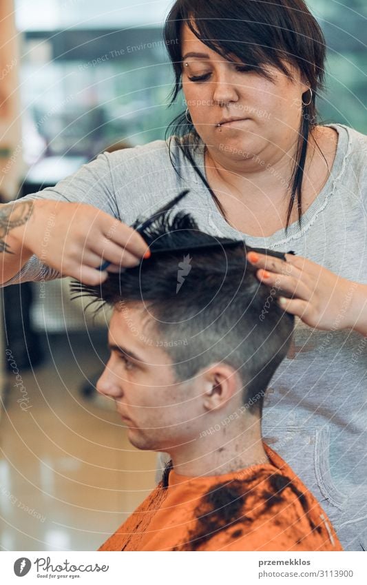 Der Friseur schneidet Haare, indem er junge Männer frisiert. Lifestyle kaufen Stil Haare & Frisuren Arbeit & Erwerbstätigkeit Beruf Schere Frau Erwachsene Mann