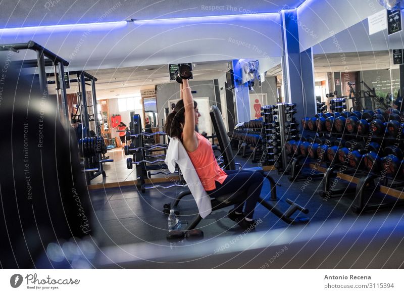 Frau beim Training im Fitnessstudio mit Gewichten Lifestyle Sport Sportler Erwachsene Lächeln muskulös Einsamkeit anstrengen Erwachsene mittleren Alters