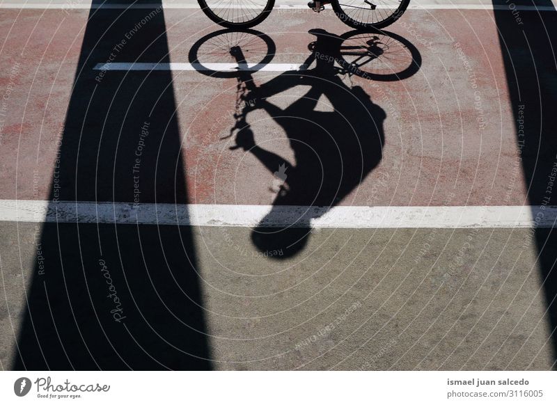 Mann auf dem Fahrrad Schatten Silhouette auf der Straße Fahrradfahren Sonnenlicht Boden Asphalt Hintergrund neutral abstrakt Verkehr Zyklus Sitz Wagenräder
