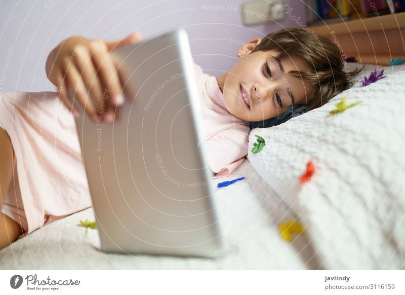 Süßes Mädchen, das einen Tablet-Computer in ihrem Schlafzimmer benutzt. Lifestyle Freude Glück schön Gesicht Freizeit & Hobby Spielen Kind Schule
