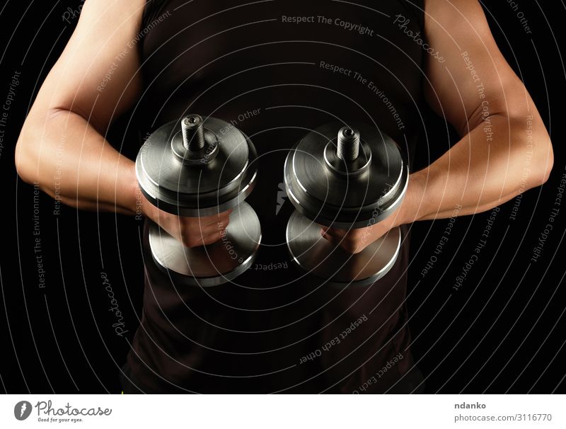 Mann in schwarzer Kleidung hält Stahlhanteln. Lifestyle Körper sportlich Fitness Sport Mensch Erwachsene Arme Hand muskulös stark Kraft abdominal Aktion Athlet