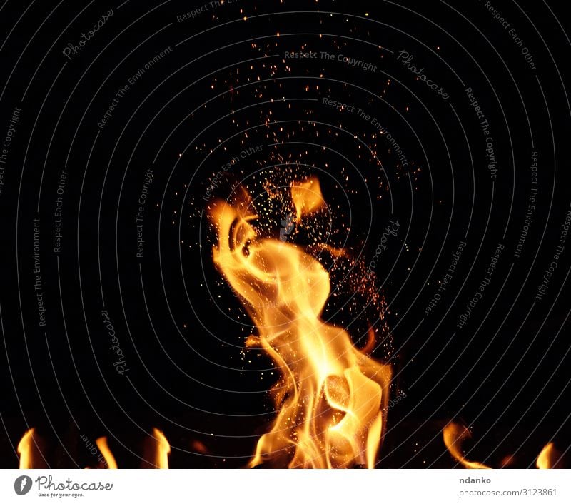 großes brennendes Lagerfeuer mit Flamme und orangenen Funken Design schön Wärme Bewegung fliegen dunkel heiß hell gelb rot schwarz Energie Farbe Hintergrund