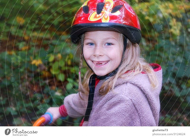 Mit Sicherheit mehr Spaß | Mädchen mit Zahnlücke und Fahrradhelm Spielen Kindheit 1 Mensch 3-8 Jahre Herbst Park Laufrad Helm blond langhaarig Lächeln lachen