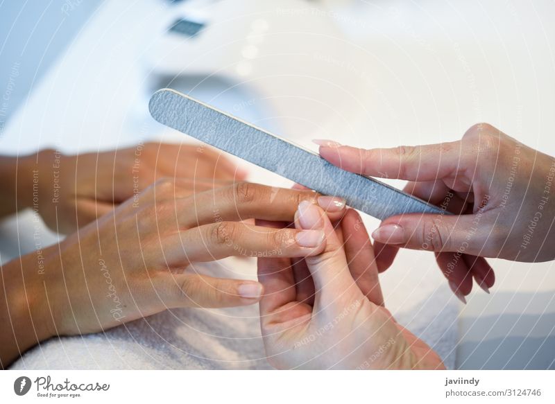 Frau in einem Nagelsalon, die eine Maniküre mit Nagelfeile erhält. schön Haut Behandlung Wellness Spa Mensch feminin Erwachsene Hand Finger 2 18-30 Jahre