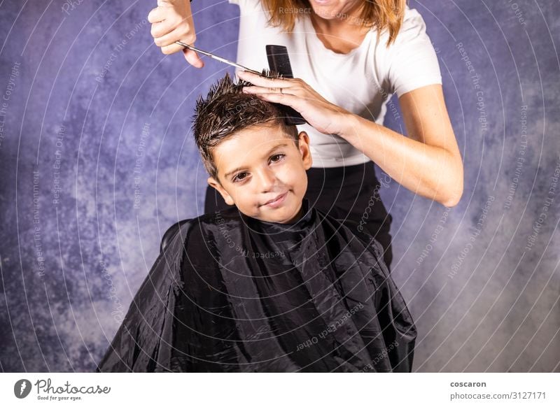 Der schöne Junge lässt sich mit der Schere die Haare schneiden. Lifestyle elegant Stil Haare & Frisuren Kind Arbeit & Erwerbstätigkeit Beruf Arbeitsplatz