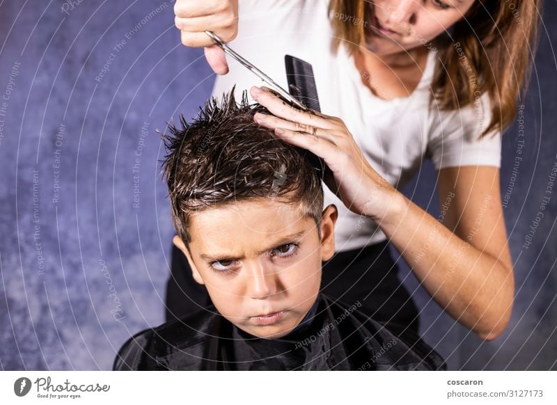 Der schöne Junge lässt sich mit der Schere die Haare schneiden. Lifestyle kaufen Stil Design Haare & Frisuren Gesicht Kind Beruf Friseur Arbeitsplatz Business