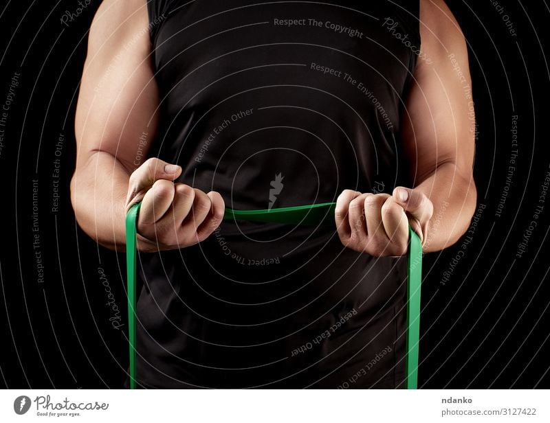 Athlet mit einem muskulösen Körper in schwarzer Kleidung Lifestyle sportlich Fitness Sport Sportler Mensch Mann Erwachsene Arme Hand Band stark grün Kraft