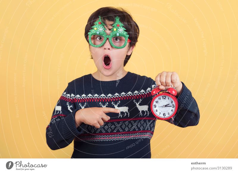 Überraschtes Kind mit Wecker Tragen einer lustigen Weihnachtsbrille Freude Winter Uhr Feste & Feiern Weihnachten & Advent Silvester u. Neujahr Mensch maskulin