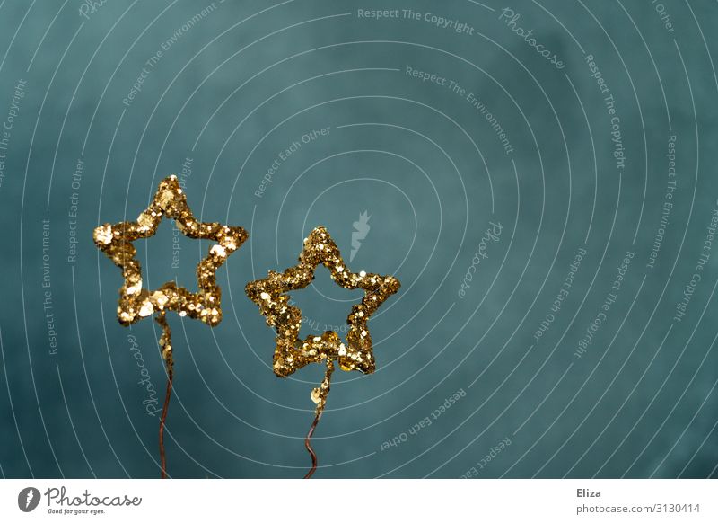 Zwei gold glitzernde Sterne vor blauem Hintergrund. Weihnachten, Advent, Dekoration. Dekoration & Verzierung Weihnachten & Advent Silvester u. Neujahr glänzend