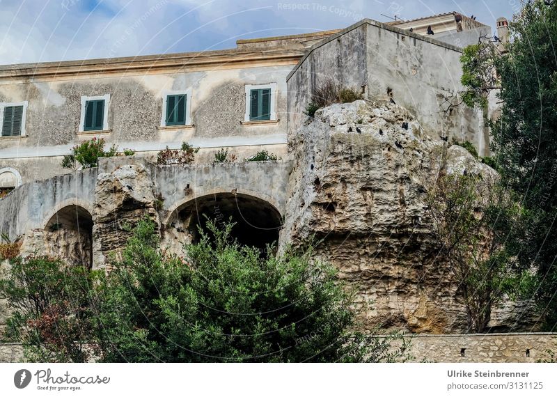 Haus auf Felsen gebaut in Sardinien Gebäude Gestein felsenfest Sedini Altbau stabil Altstadt Höhlen untergraben Architektur Fensterläden grau grün Felsvorsprung