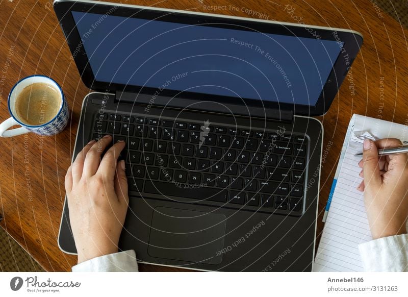 Draufsicht einer Frau, die ihren Laptop auf einem Holztisch benutzt. Kaffee Lifestyle kaufen Freizeit & Hobby Schreibtisch Tisch Arbeit & Erwerbstätigkeit