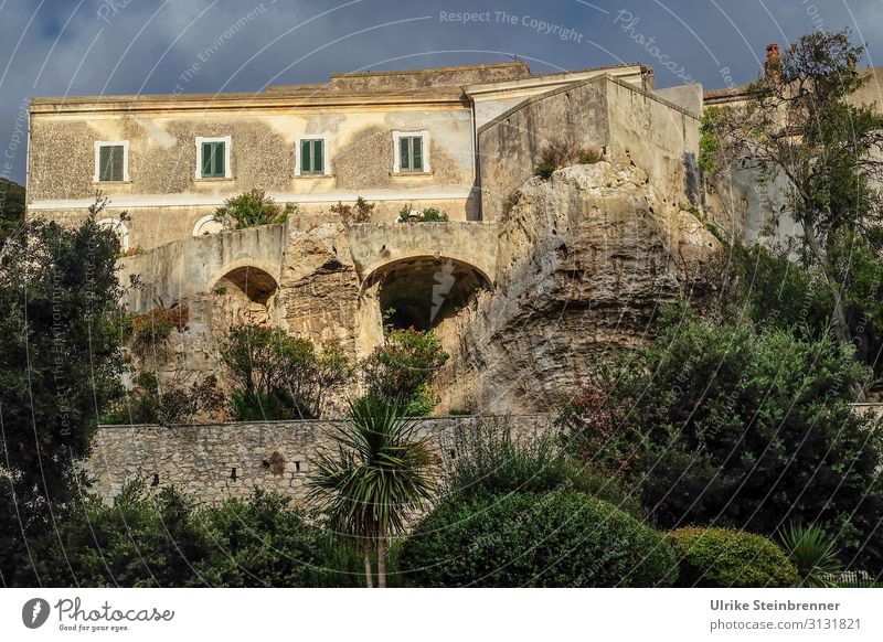 Haus auf Felsen gebaut in Sardinien in der Abendsonne Gebäude Gestein felsenfest Sedini Altbau stabil Altstadt Höhlen untergraben Architektur Fensterläden grau