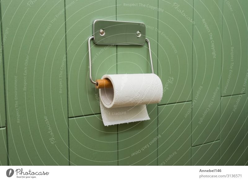 Eine weiße Rolle weiches Toilettenpapier, die sauber am Halter hängt. elegant Design Haus Dekoration & Verzierung Bad Papier Metall frisch neu Sauberkeit braun