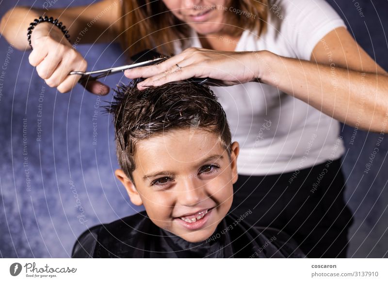 Der schöne Junge lässt sich mit der Schere die Haare schneiden. Lifestyle Stil Haare & Frisuren Gesundheitswesen Kind Arbeit & Erwerbstätigkeit Beruf