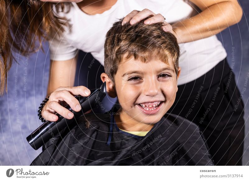 Kleiner Junge lässt sich mit einer Schneidemaschine die Haare schneiden. Lifestyle kaufen Stil schön Haare & Frisuren Gesicht Spielen Kind Beruf Friseur