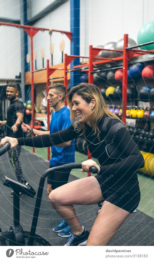 Sportlerin beim Airbike im Fitnessstudio Lifestyle Freude Glück Ball Mensch Frau Erwachsene Partner Lächeln authentisch Luftrad Training durchkreuzen passen