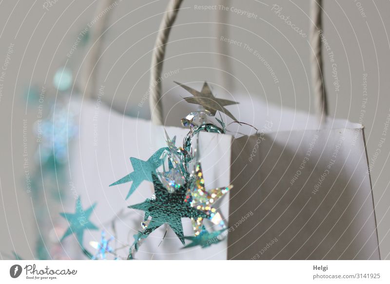türkise und silberne Sterne hängen an als Dekoration an einer weißen Papiertasche Feste & Feiern Weihnachten & Advent Dekoration & Verzierung Tüte