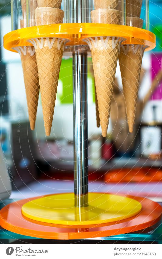 Waffelkegel für Eiscreme auf den Ständer gestellt. Eisdiele. Dessert Speiseeis Sommer Coolness frisch lecker gelb Kegel Lebensmittel Sahne Zapfen kalt Knusprig