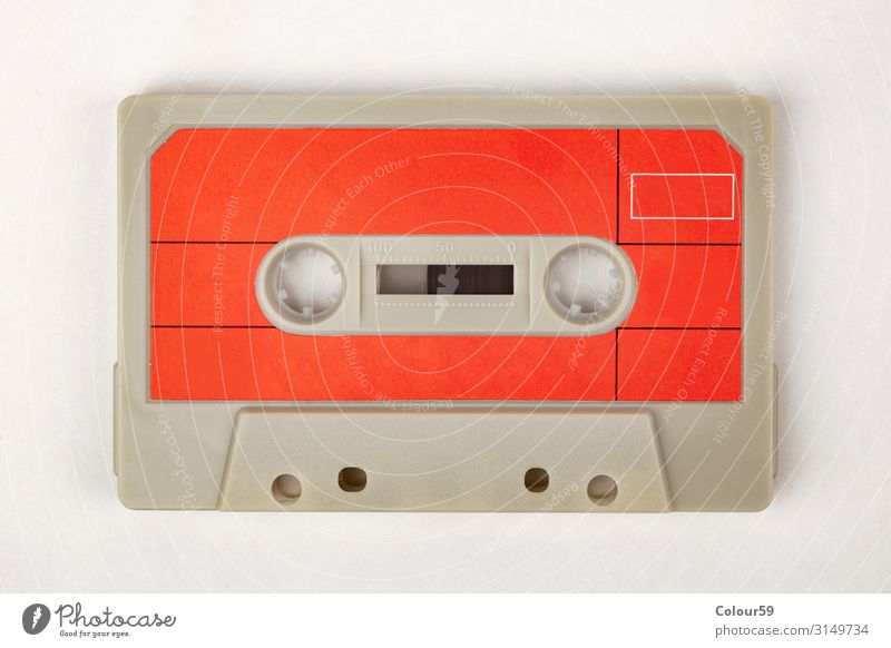 Musikkassette mit rotem Etikett retro Audio 80s Disco Hintergrundbild label analog tonband kultig musik hören Farbfoto Vogelperspektive