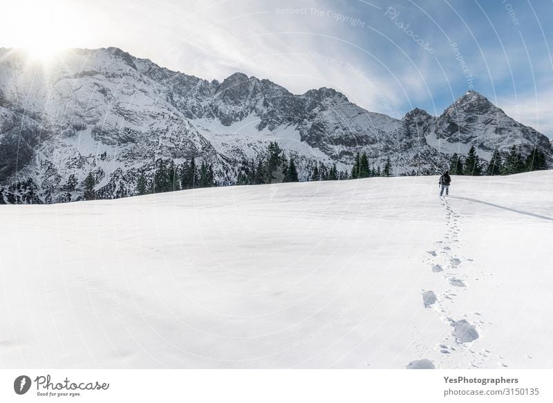 Winterberge und Mann, der durch den Schnee geht. Schritte im Schnee Abenteuer Berge u. Gebirge wandern Erwachsene 1 Mensch Natur Landschaft Sonne Klimawandel