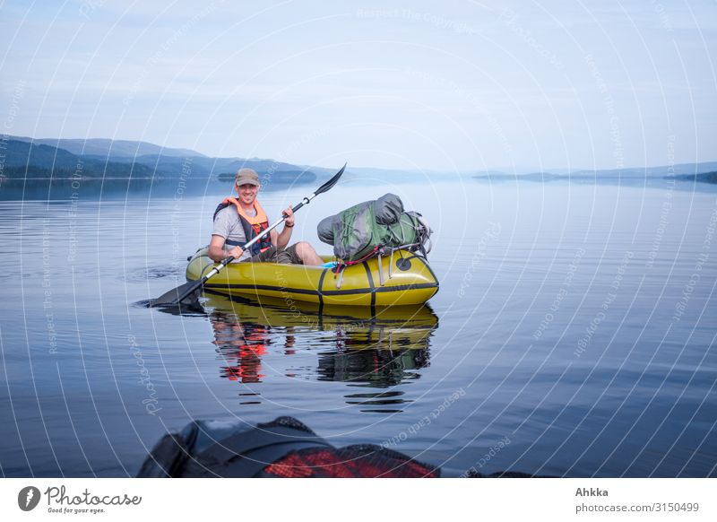 Junger Mann im Kajak auf einem windstillen See Boot Kanu Paddeln blau Ausgeglichenheit Windstille Abenteuer Kanutour Kontrolle authentisch