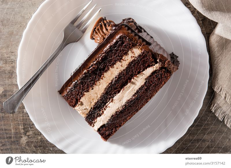 Schokoladenkuchenscheibe auf Holztisch Backwaren Kuchen Scheibe süß Dessert Pasteten Lebensmittel Foodfotografie gebastelt Sahne Torte Pudding backen