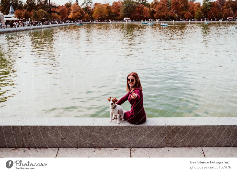 junge Frau und süßer Hund am See in einem städtischen Park. Konzept der Liebe zu Tieren. Retiro-Park Madrid Haustier Außenaufnahme Großstadt Umarmen