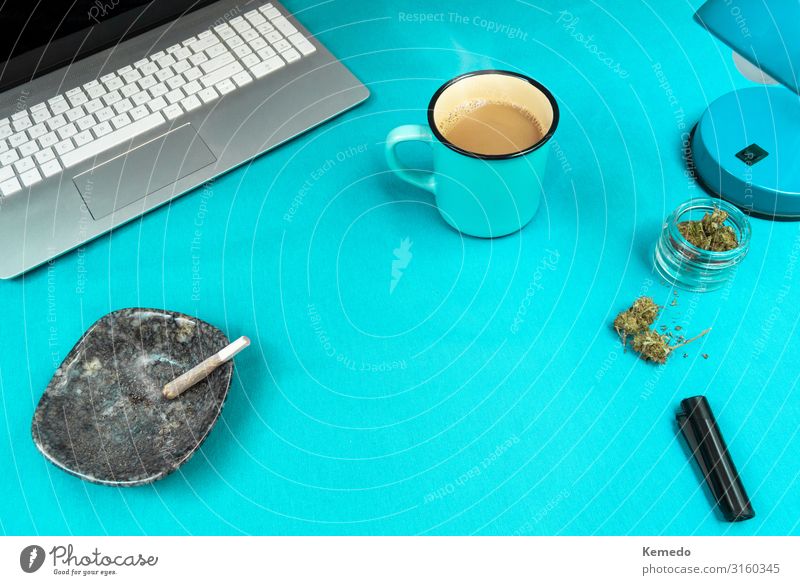 Blauer Arbeitsplatz mit Marihuana Joint, Kaffeetasse und Computer. Süßwaren Frühstück Bioprodukte Lifestyle Design Rauchen Rauschmittel Wellness Leben Erholung