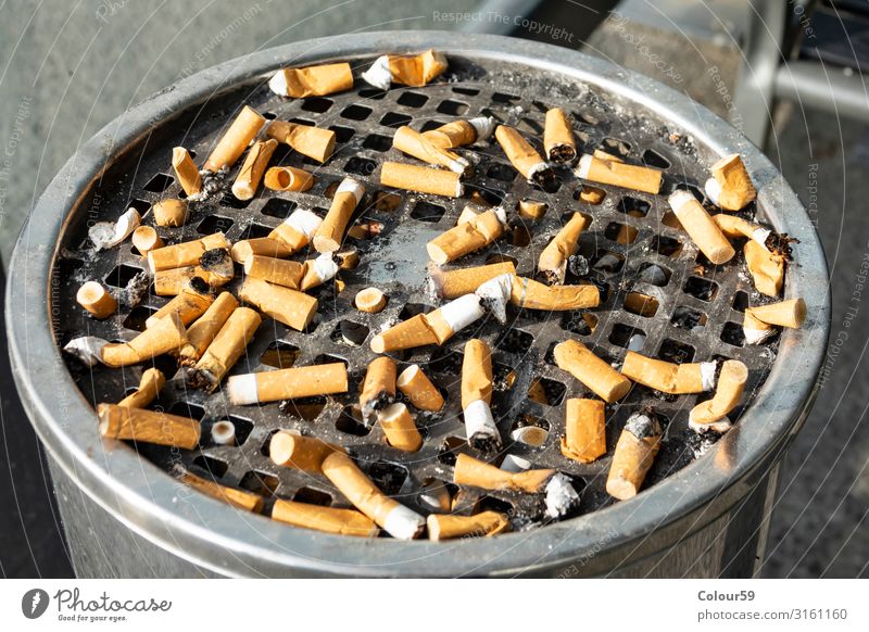 lustige Aschenbecher voller Zigaretten auf weißem Stockfoto