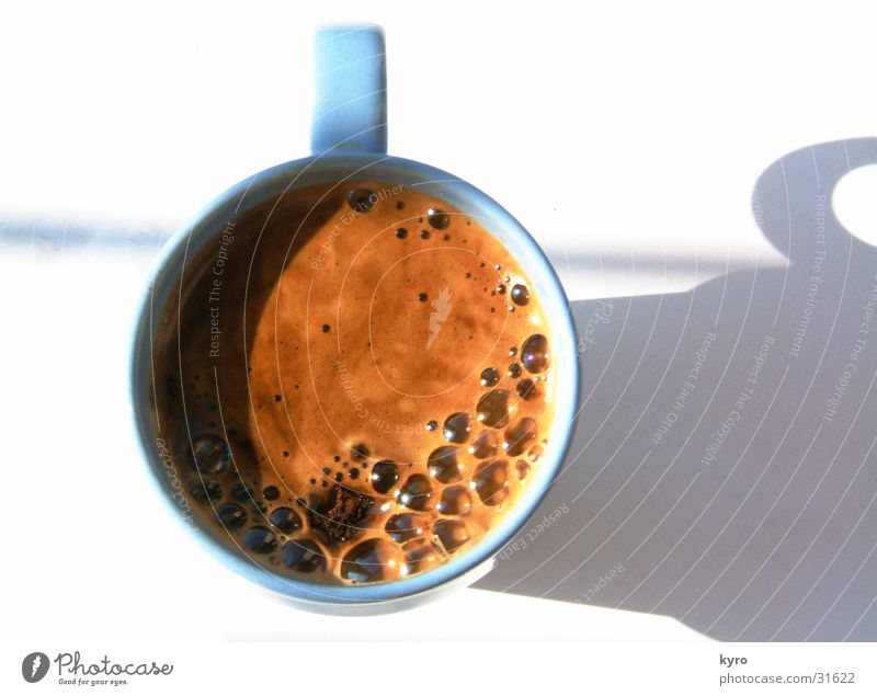 Tasse Kaffee Café Schaum rund Tragegriff braun stark Trennung Bohnen Pulver Küche Sonne blasen springen blau hell Schatten oben