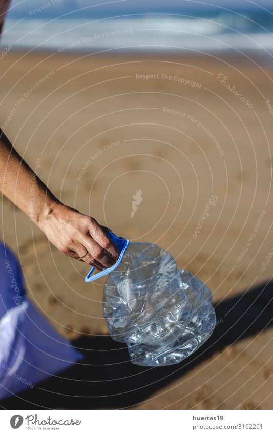 Frau, die Müll und Plastik aufhebt und den Strand reinigt. Flasche Lifestyle Meer Erwachsene Hand Umwelt Natur Sand Küste Hund Paket Kunststoff nachhaltig