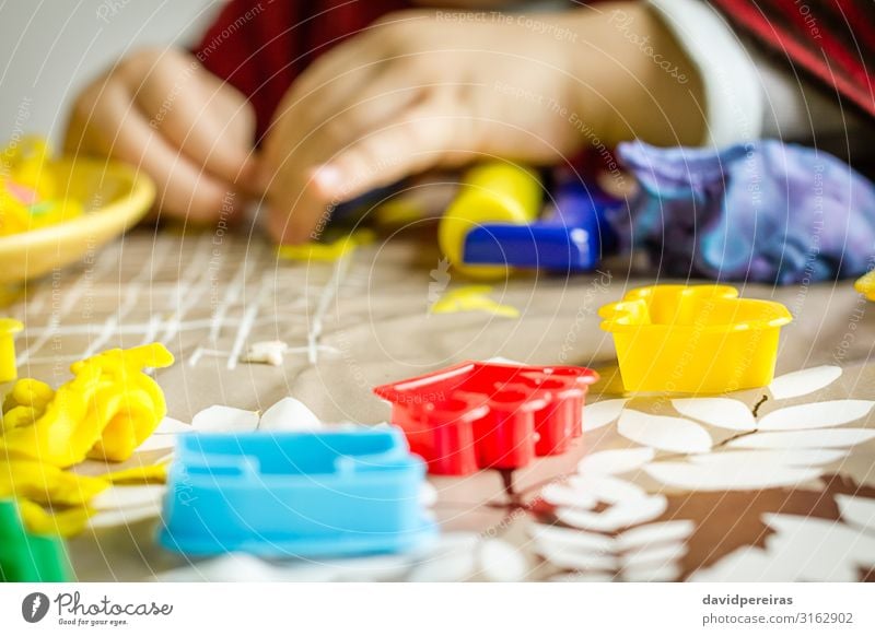 Nahaufnahme von Plastikformen und Kinderhänden auf dem Hintergrund Teigwaren Backwaren Freude Spielen Tisch Junge Kindheit Spielzeug niedlich Kreativität Aktion