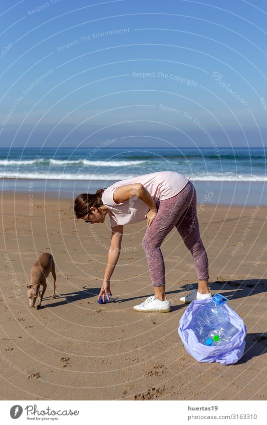 Frau mit Hund, die Müll und Plastik aufhebt und den Strand reinigt. Flasche Lifestyle Meer Mensch feminin Erwachsene Hand 30-45 Jahre Umwelt Natur Landschaft