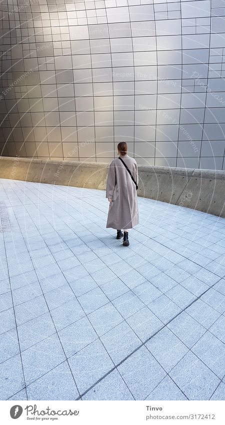 Frau in langem Mantel geht allein über einen futuristisch anmutenden Platz Erwachsene 1 Mensch 18-30 Jahre Jugendliche Architektur gehen Beginn Ende entdecken