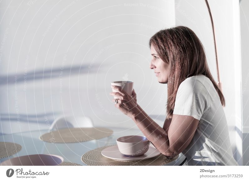 Frau, die auf dem Wohnzimmer sitzt und eine Tasse Tee hält. Frühstück Getränk trinken Heißgetränk Kaffee Lifestyle Glück schön Erholung Freizeit & Hobby Haus