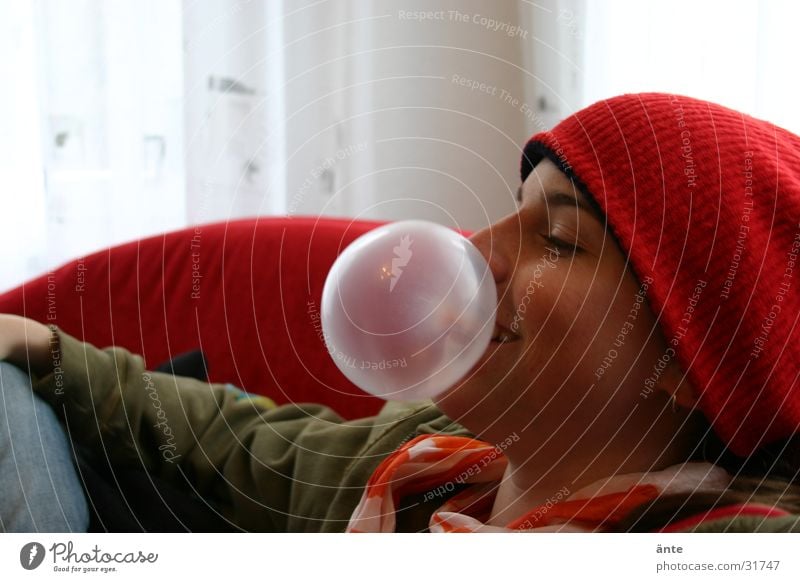 Die Kaugummiblase platzen Kindererziehung bestrafen anstößig ungehorsam Verhaltensregel Mütze rot grün Halstuch Sofa Fenster Freude Baseballmütze lustig