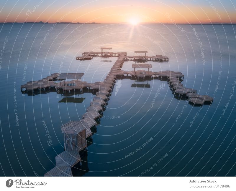 Überwasserpier des Resorts bei Sonnenuntergang Anlegestelle über Wasser Architektur Himmel Fluggerät Drohnenansicht hell Horizont abgelegen Holz geometrisch