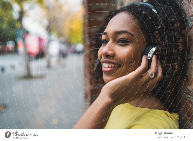 Afroamerikanerin beim Musikhören Lifestyle Stil Freude Erholung Freizeit & Hobby Entertainment Frau Erwachsene Straße Afro-Look genießen Lächeln Coolness