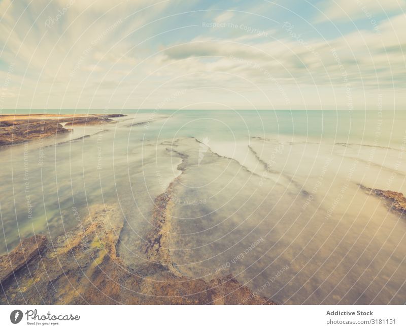 Felsige Küste unter blauem Himmel Meer Landschaft Felsen Abenddämmerung Wolkenlandschaft Stein marin Rippeln Wetter horizontal Außenaufnahme Textfreiraum Wellen