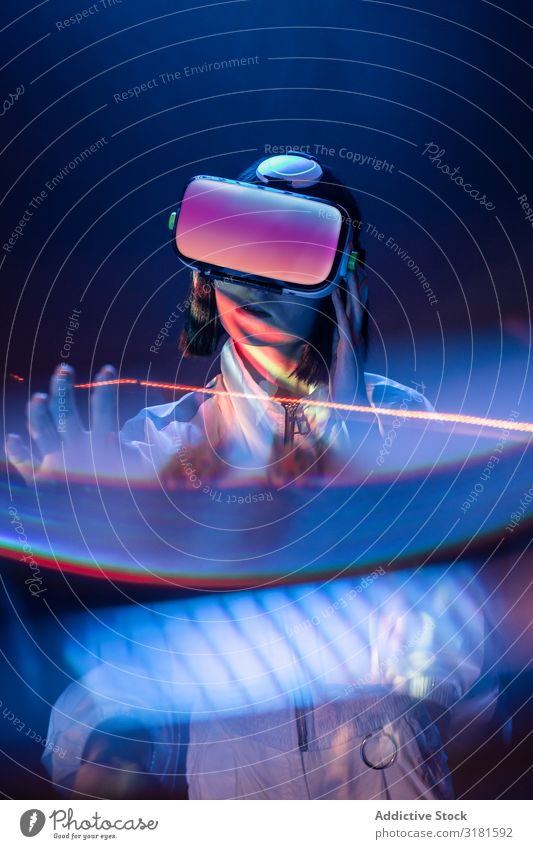 Frau berührt Luft in VR-Brillen asiatisch Headset Virtuelle Realität Technik & Technologie neonfarbig Licht berühren Gerät digital Innovation Brillenträger