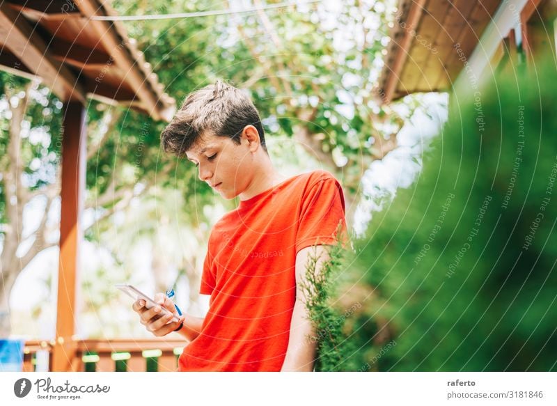 Profil eines glücklichen männlichen Teenagers, der auf einem Smartphone schreibt. Glück Telefon Handy PDA Mensch maskulin Junge Mann Erwachsene Jugendliche 1