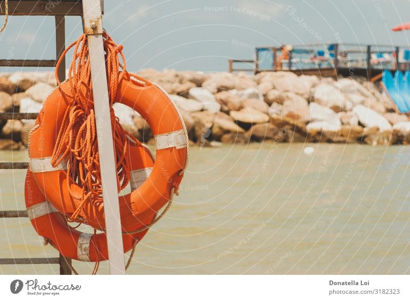 Zwei orangefarbene Rettungsringe am Strand sparen Ferien & Urlaub & Reisen Tourismus Ausflug Sommer Meer Wärme Stein Sand maritim Schutz Sicherheit Überleben