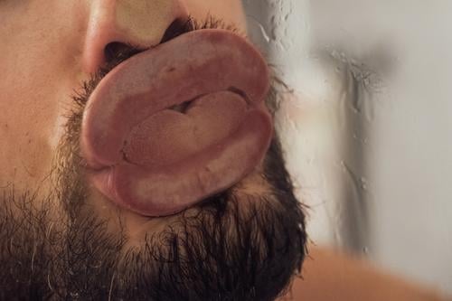 Ekliger Knutscher gegen eine Glasscheibe Zunge Mund Lippen Küssen schlecht Kuss knutschen Zungenkuss eklig bäh Belästigung Sexuelle Belästigung nass Dusche